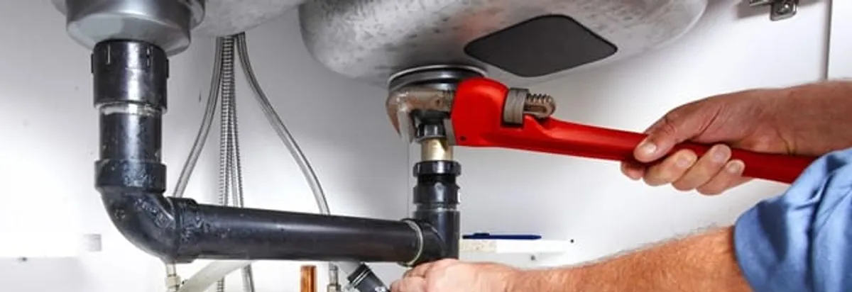 Garbage disposal repair technician tightening the sink drain and disposal connection in Jackson, MS