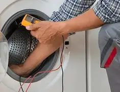 Washing machine repair technician testing a front-load washer with diagnostic tools in Jackson, MS